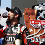 SONOMA, CALIFORNIA - JUNE 12: Daniel Suarez, driver of the #99 Onx Homes/Renu Chevrolet, celebrates by drinking wine in victory lane after winning the NASCAR Cup Series Toyota/Save Mart 350 at Sonoma Raceway on June 12, 2022 in Sonoma, California. (Photo by Chris Graythen/Getty Images)